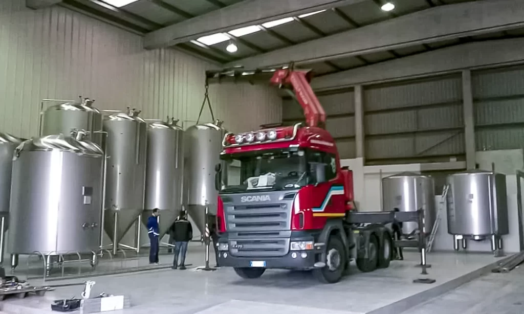 Marcarini Autotrasporti posizionamento silos con gru nel capannone